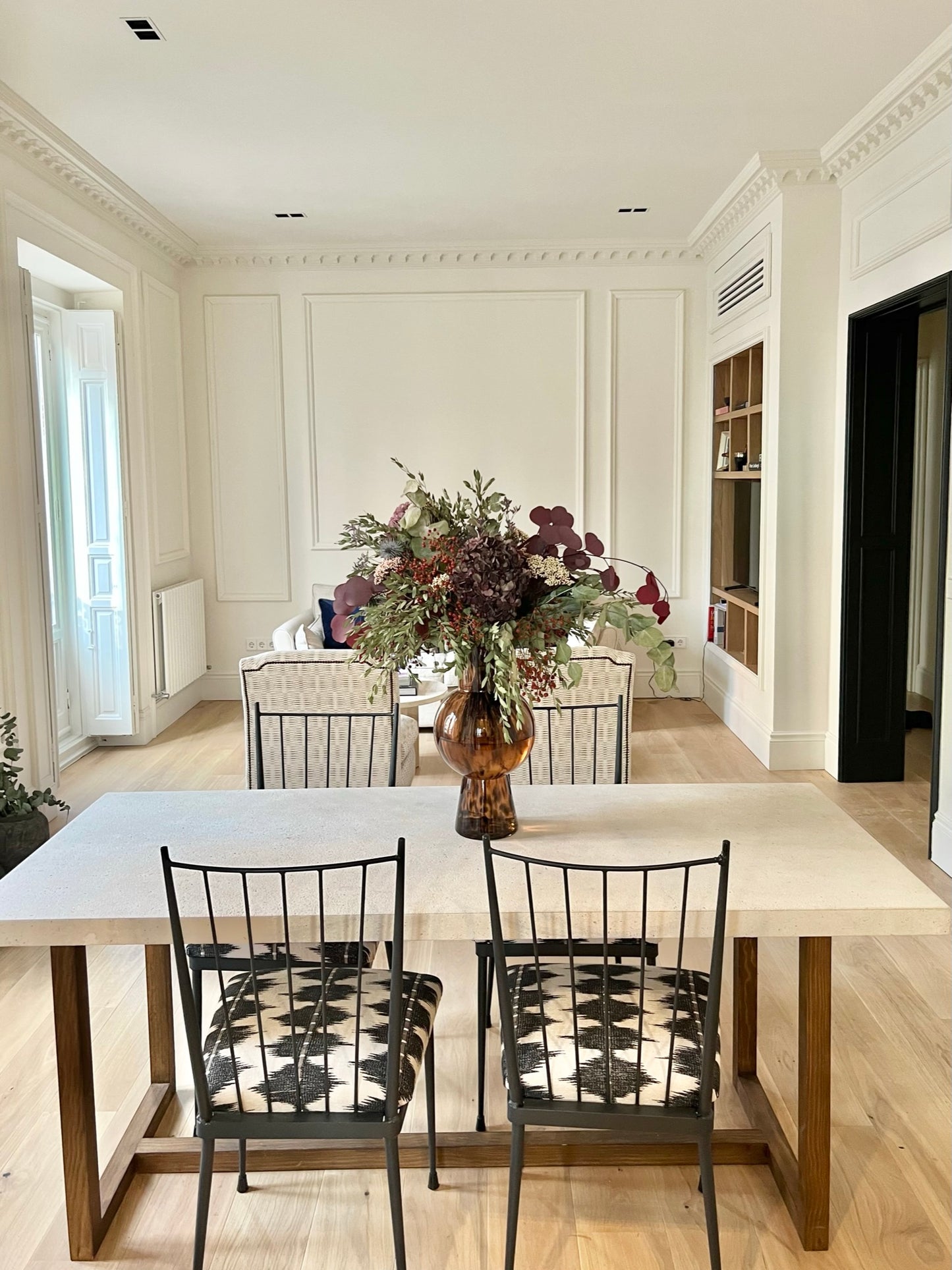 Mesa de comedor con base de madera y tapa de piedra.